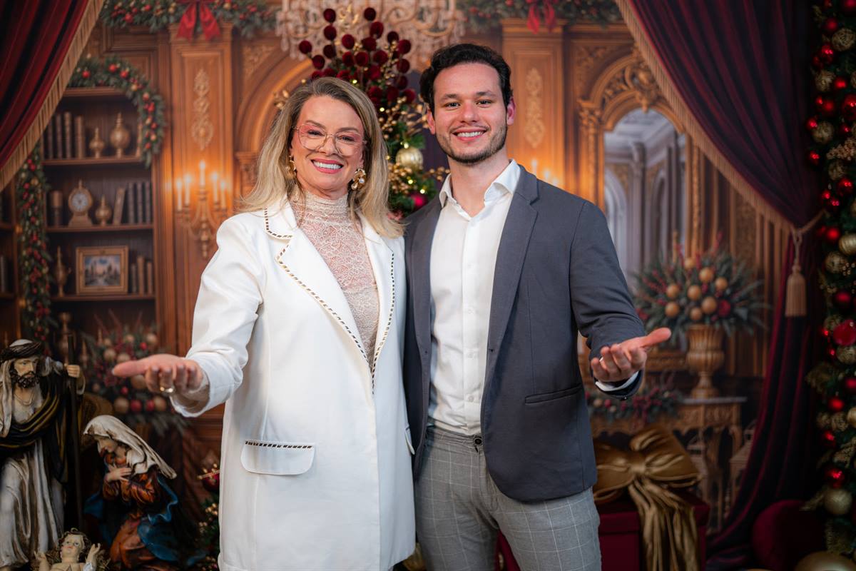Rose e Douglas, da Rose Decor, lado a lado e sorrindo, em cenário natalino decorado.